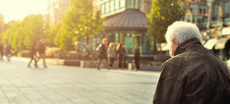 Man Sitting on Wooden Bench Wearing Black Leather Jacket