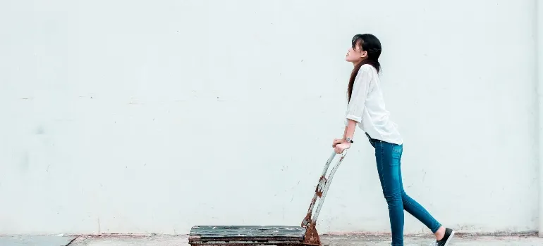 woman driving dollies thinking about pros and cons of DIY moving