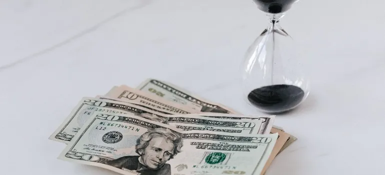 sand clock and money on the table
