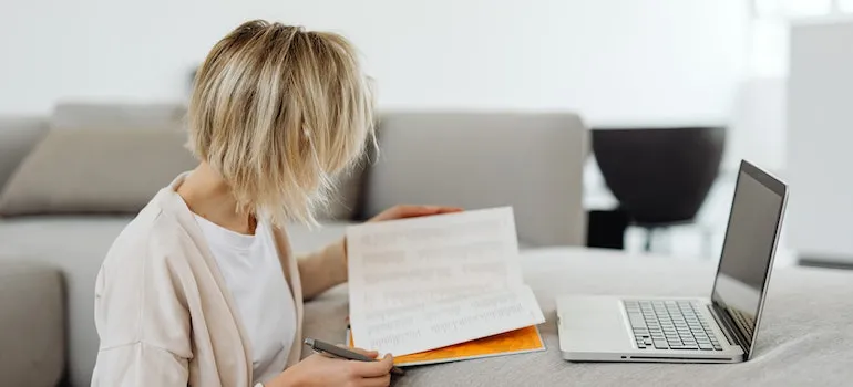 A woman doing a background check on a moving company in order to avoid common moving scams.