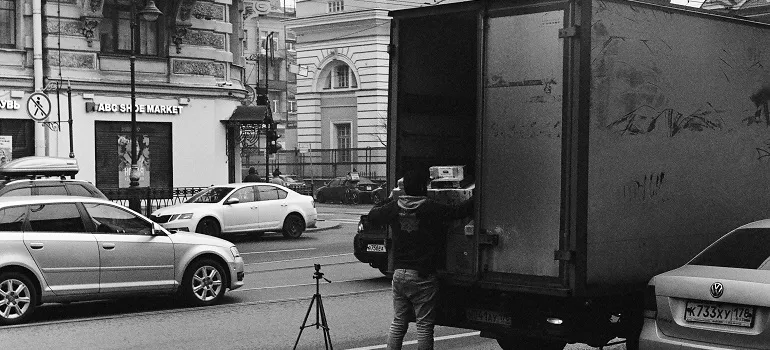 mover loading things into a truck in a busy street