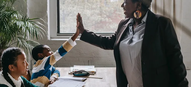 a kid high-fiving a teacher