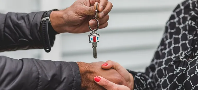 a realtor handing the house keys to the new homeowner