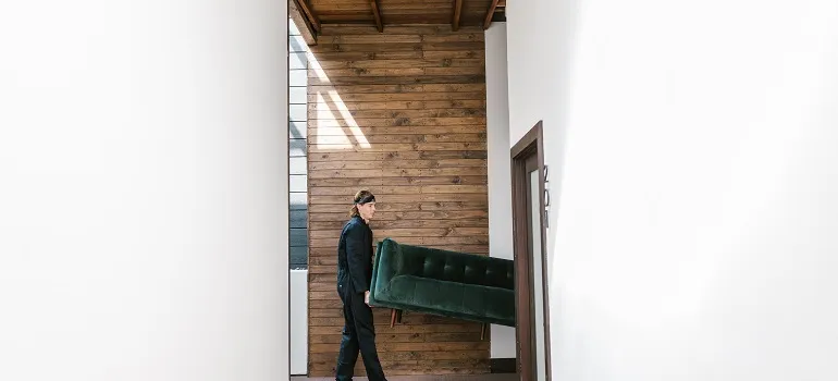 a mover carrying a large sofa