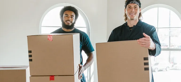 movers holding moving boxes