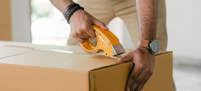 man taping a box