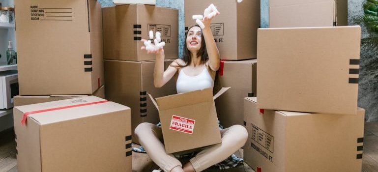 woman sitting among boxes