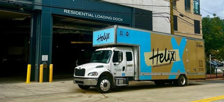 A moving truck parked in front of a building.