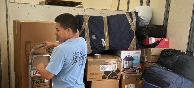 A professional mover stacking boxes inside a moving truck.