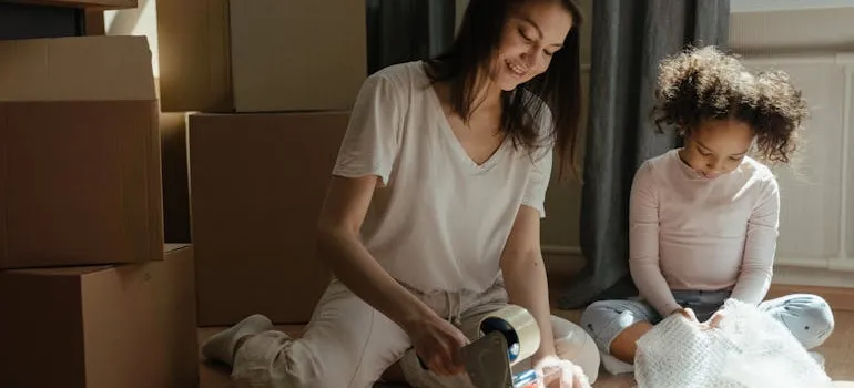 A mother and a daughter packing their items for a rush interstate move to North Carolina.