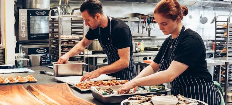 Two people working in a kitchen.