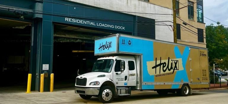 A moving truck parked in front of a building.