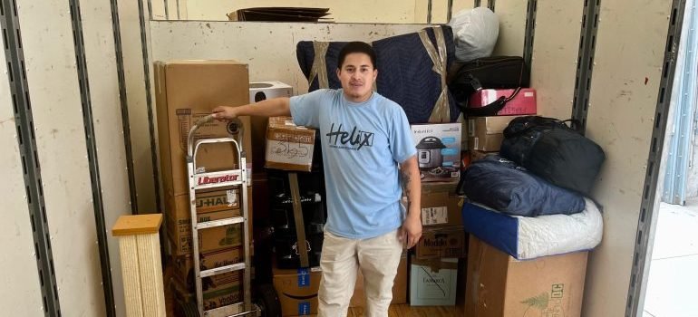 A professional mover next to some items packed into boxes.