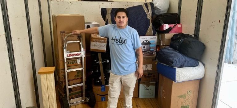A mover surrounded with packed items in a moving truck.