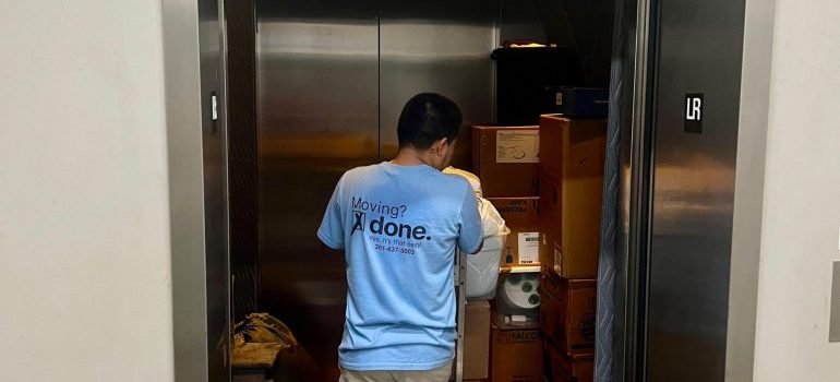A professional mover loading some packed items into an elevator.