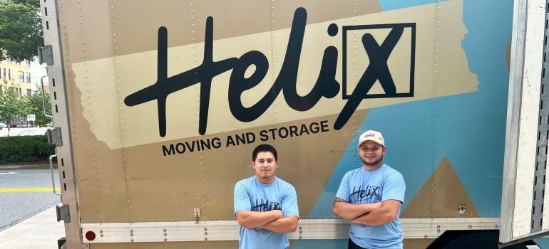 Two movers standing in front of a moving truck.