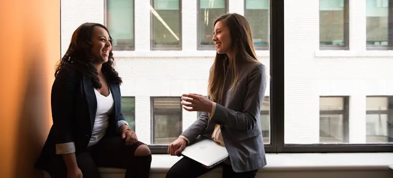 Two women talking to each other about how to find reliable movers in Montgomery County.