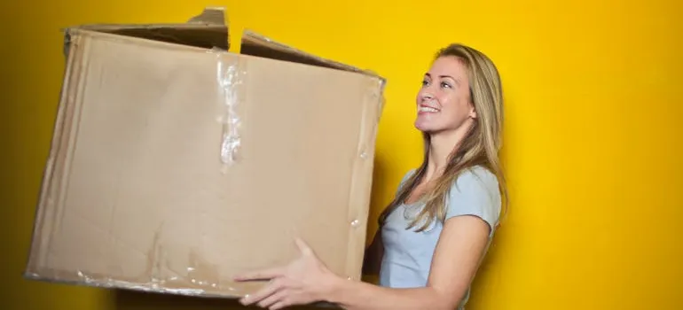 A person holding a cardboard box while moving to Silver Spring