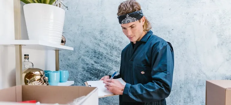 A mover checking a moving plan to help you with saving money when moving.