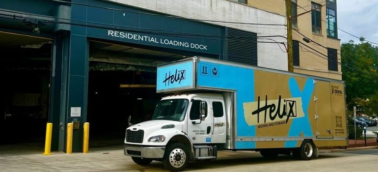 A moving truck parked in front of a building.