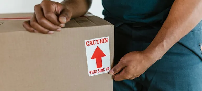 A mover safely packing and labeling office equipment