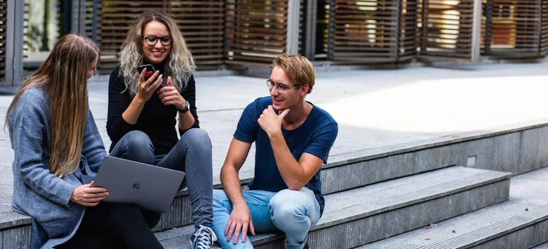 People talking to each other while sitting on the stairs.
