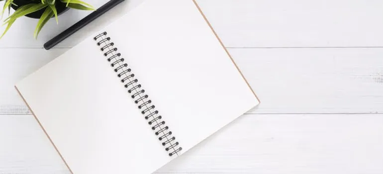 An empty notebook and a pen on a table ready to do the planning for your move abroad from Maryland.