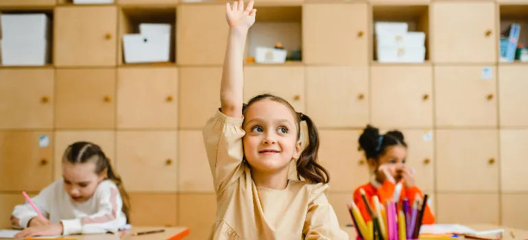 A kid in a classroom during a lesson, symbolizing excellent educational facilities as one of the reaasons why families are choosing to move to Potomac.
