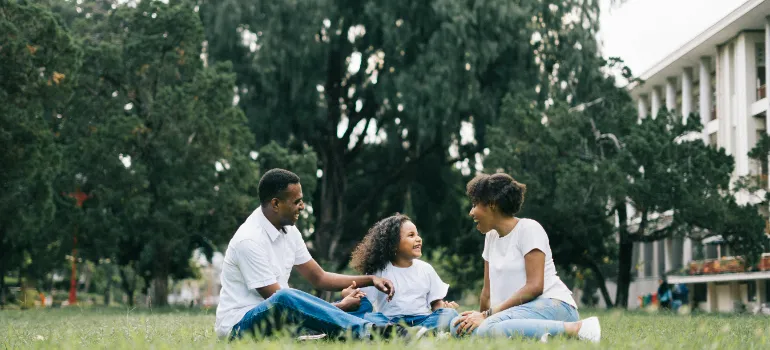 A family sitting on the grass in a park.